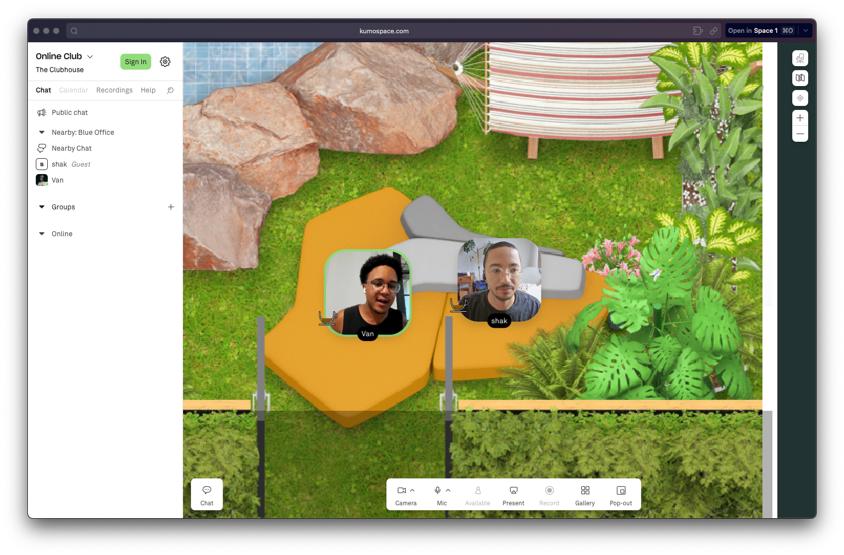 A screenshot of Kumospace, with Van and the writer, Shakeil, 'sitting' on a couch in an outdoor area with plants and a water feature nearby.